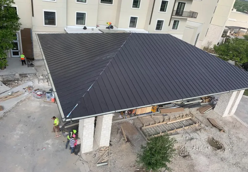 Metal roofing installation team working on a commercial building in Marshall